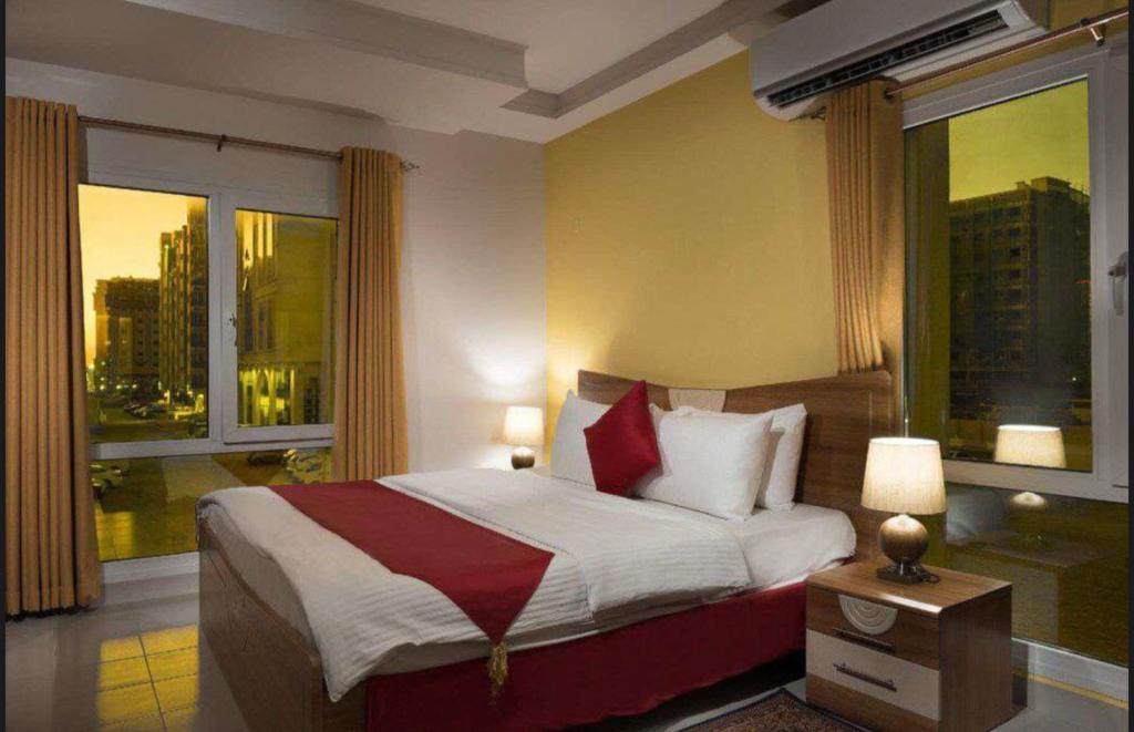 AL MANAF HOTEL SUITES tesisinde bir odada yatak veya yataklar