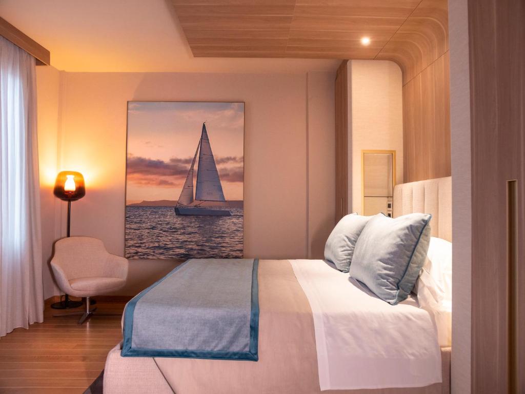 a bedroom with a bed with a sailboat painting on the wall at Miramare Suites in Sestri Levante