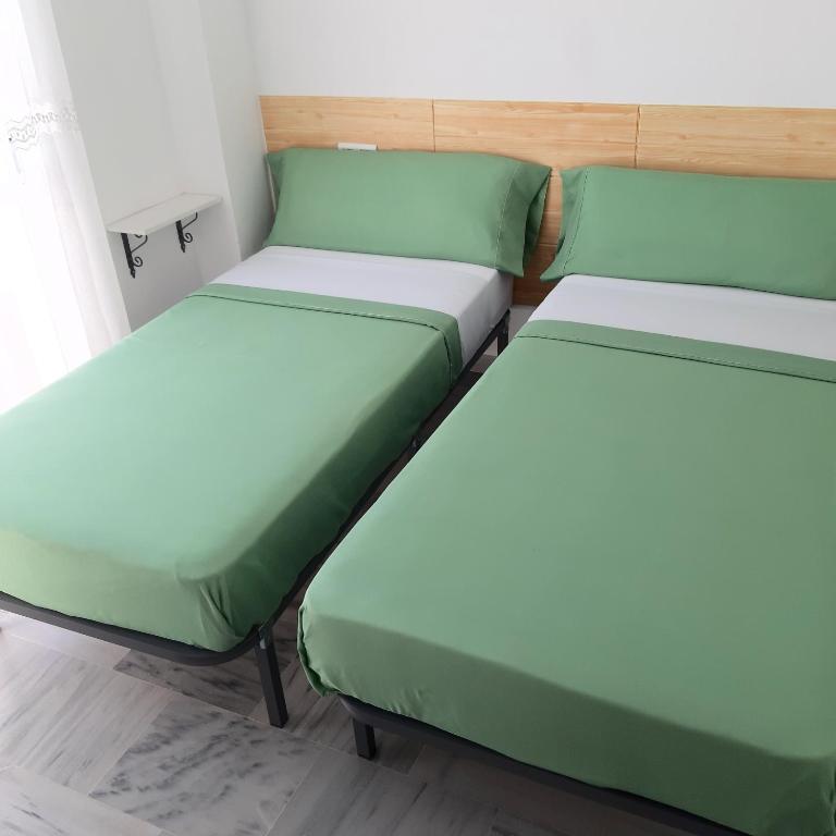 2 camas en una habitación con verde y blanco en Aldea Beach en Castillo de Sabinillas