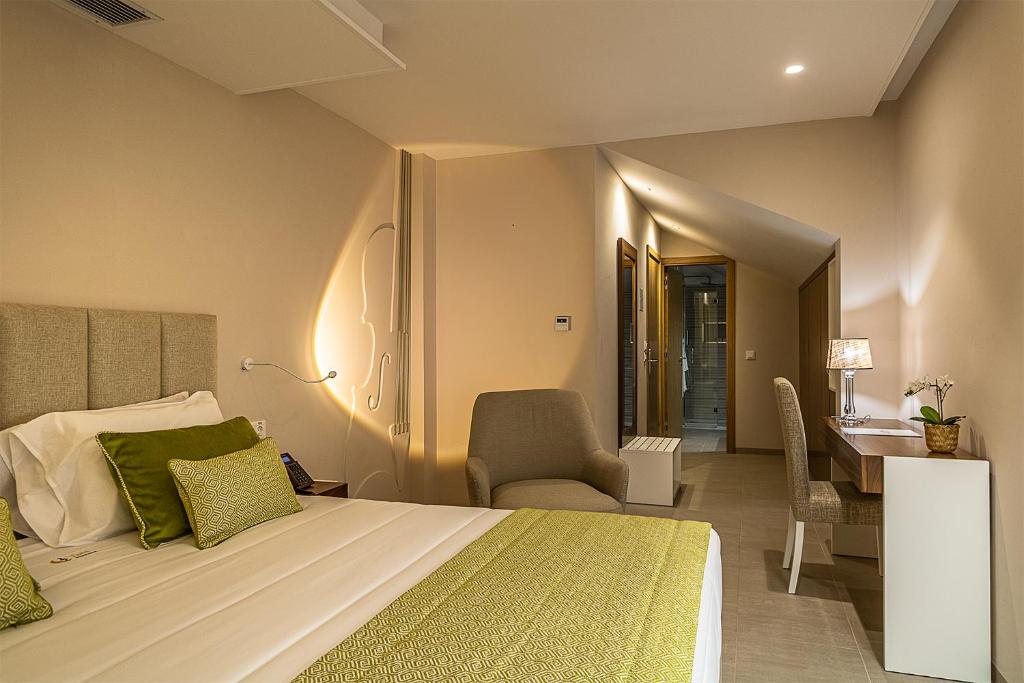 a bedroom with a bed and a desk and a chair at Luna Boutique Hotel in Mindelo