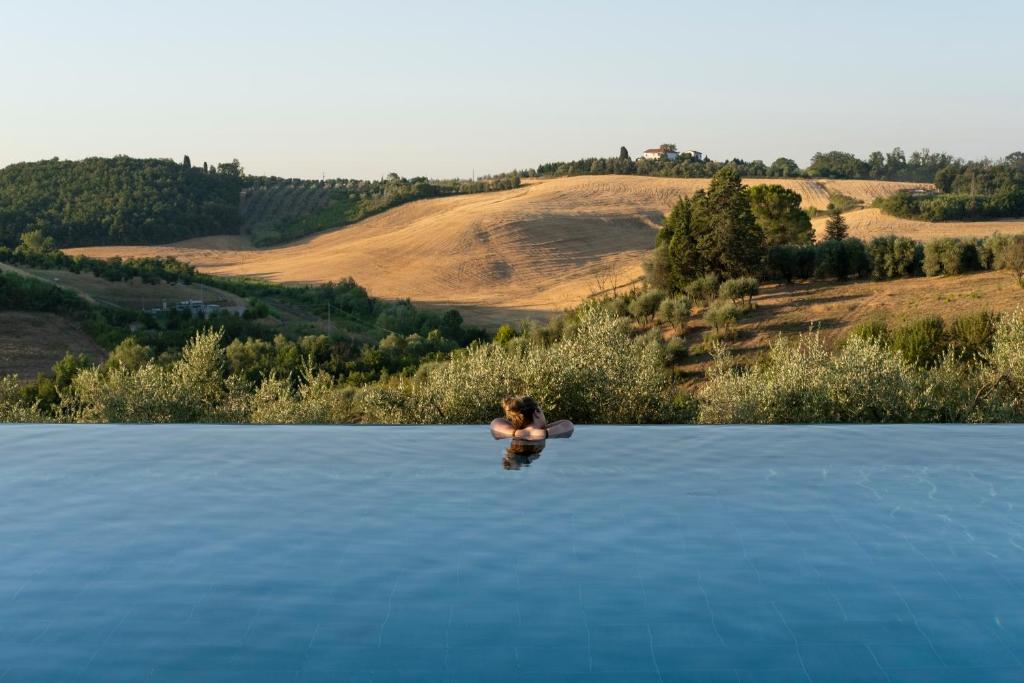 una persona nadando en un cuerpo de agua en Villa Petriolo, en Cerreto Guidi