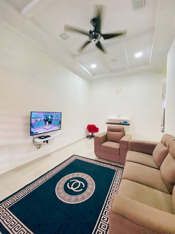 a living room with a couch and a tv at Rawyna homestay segamat in Segamat