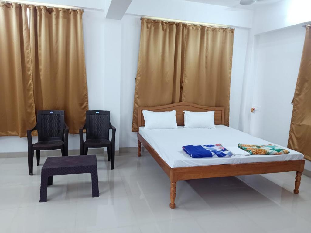 a bedroom with a bed and two chairs at KIHIM HOLIDAY HOME in Kīhīm