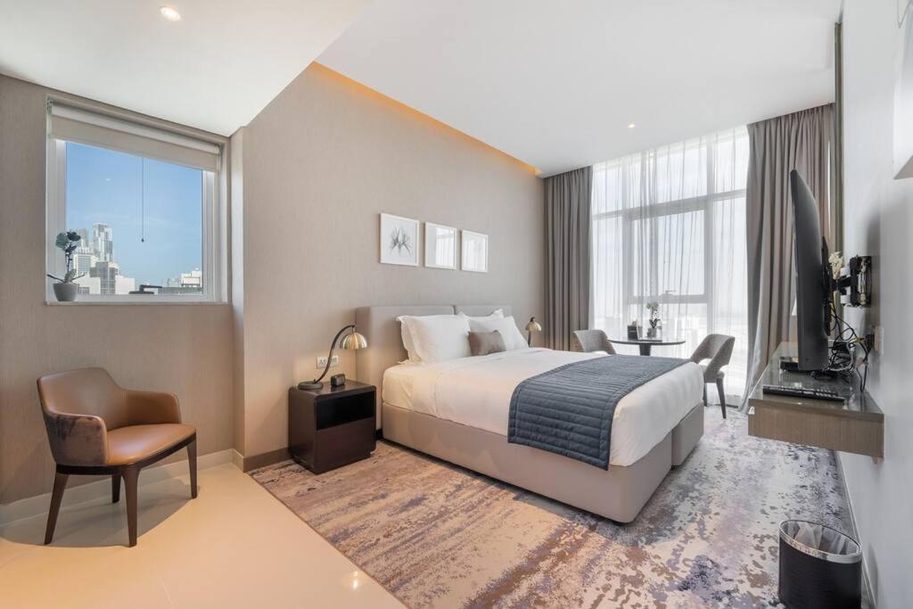 een grote hotelkamer met een bed en een televisie bij At The Top Burj View STUDIO - Special offer in Dubai