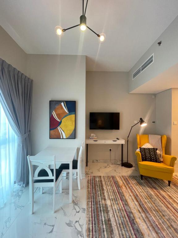 a living room with a table and a desk and a tv at MAG 565, Boulevard, Dubai South, Dubai in Dubai