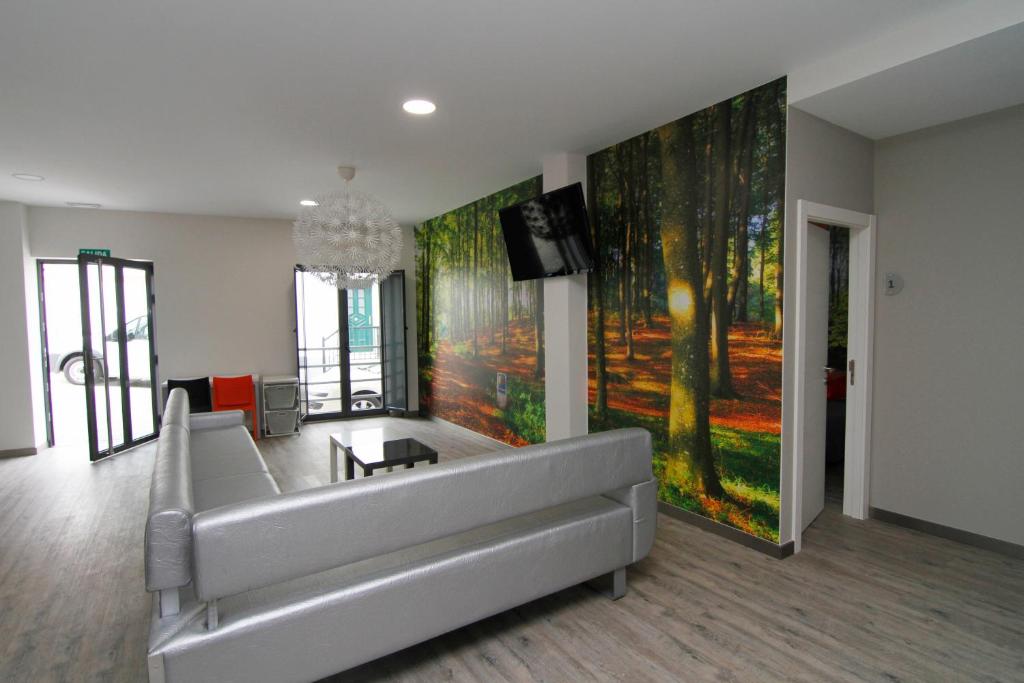 a living room with a couch and a tv at ALBERGUE SAN MARCOS in Palas de Rei