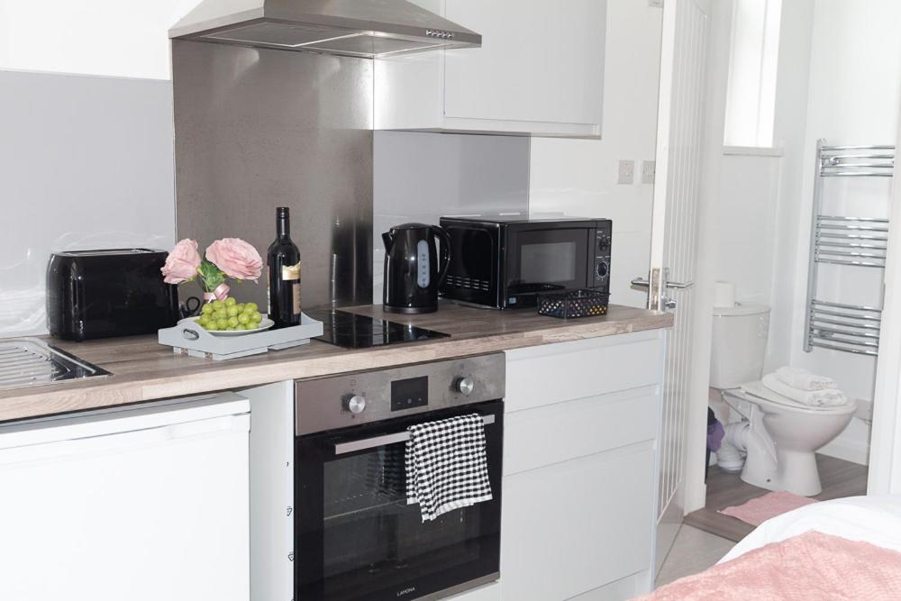 a kitchen with a stove top oven and a microwave at Vion Apartment - King Suites in Aberdeen
