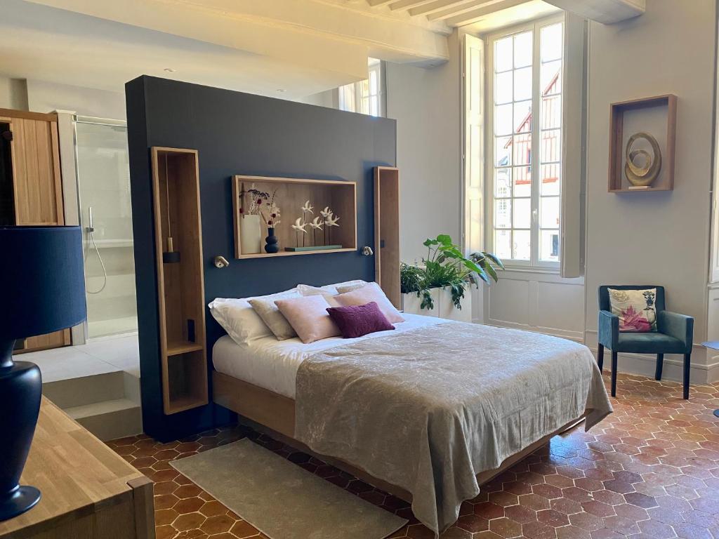 een slaapkamer met een groot bed met een blauw hoofdeinde bij Suite avec Spa Quartier Cathédrale in Autun