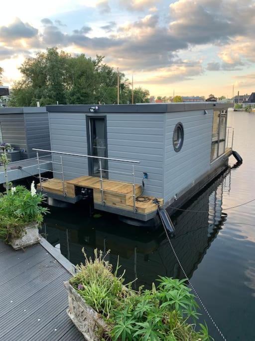 a house boat parked at a dock in the water at Unique new houseboat moored 4 in Zwartsluis