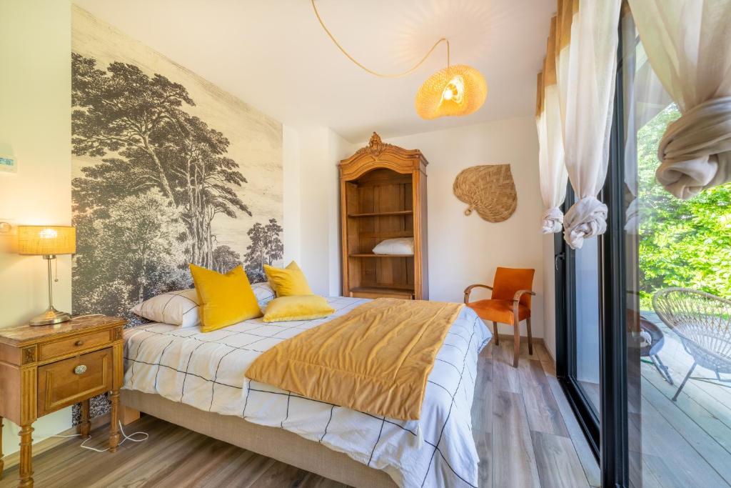 a bedroom with a bed with yellow pillows and a window at MAISON SWANNEL - Cosy & Spa in Andernos-les-Bains