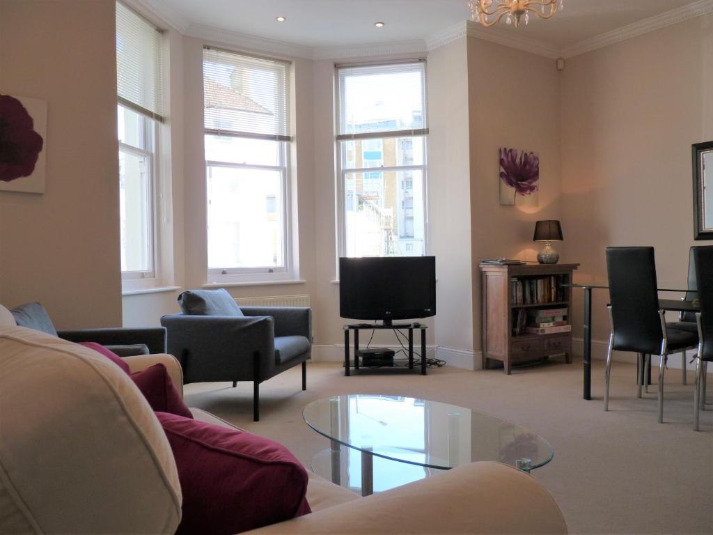 - un salon avec un canapé et une télévision dans l'établissement Cavendish apartment - central and spacious, à Eastbourne