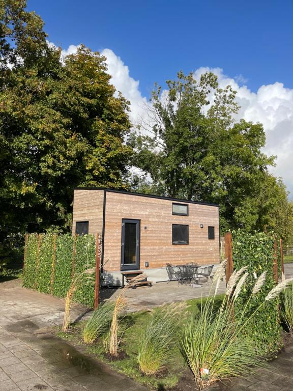 een klein huisje in een tuin met een hek bij Tiny House Indy-Blue in Giethoorn