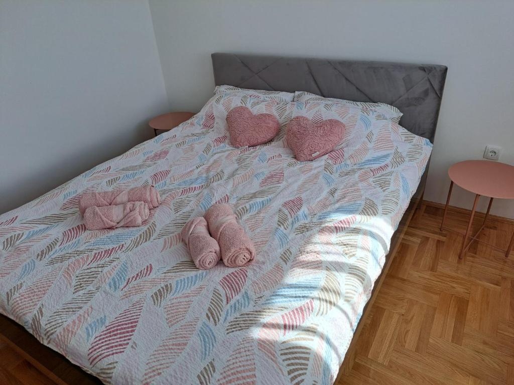 a bed with two hearts and two pairs of shoes at On Top 21 in Bijeljina