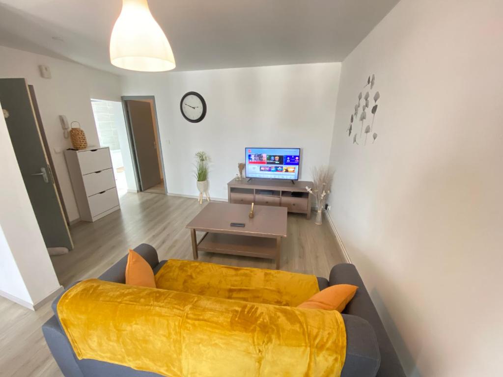 - un salon avec un canapé jaune et une table dans l'établissement Joli appartement avec parking gratuit sur place, à Givet