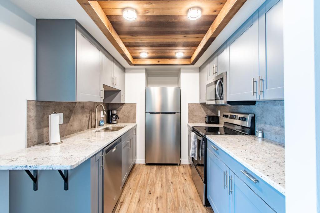 a kitchen with blue cabinets and a stainless steel refrigerator at Modern, Rustic 2 Bed 1 bath 6 blocks from Mayo in Rochester