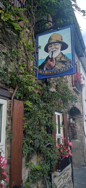 a sign hanging on the side of a building at Mariners Rest One Bedroom Apartment in Innishannon Village in Cork