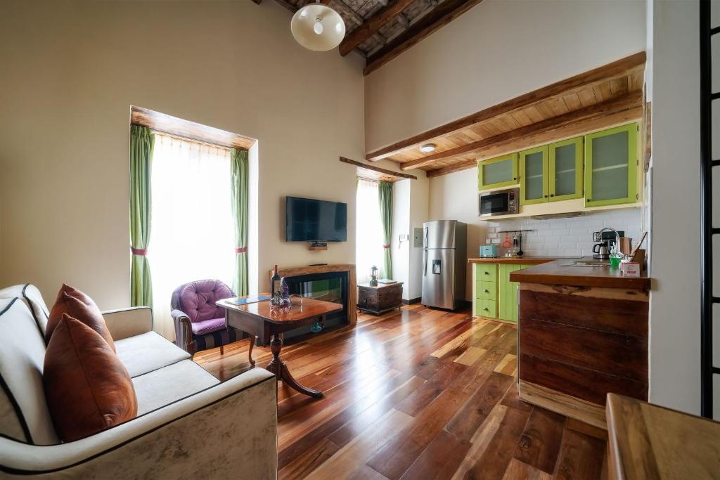 a kitchen and living room with a couch and a table at Old Town Quito Suites, Heritage Boutique Hotel, Where Every Detail Tells a Story in Quito