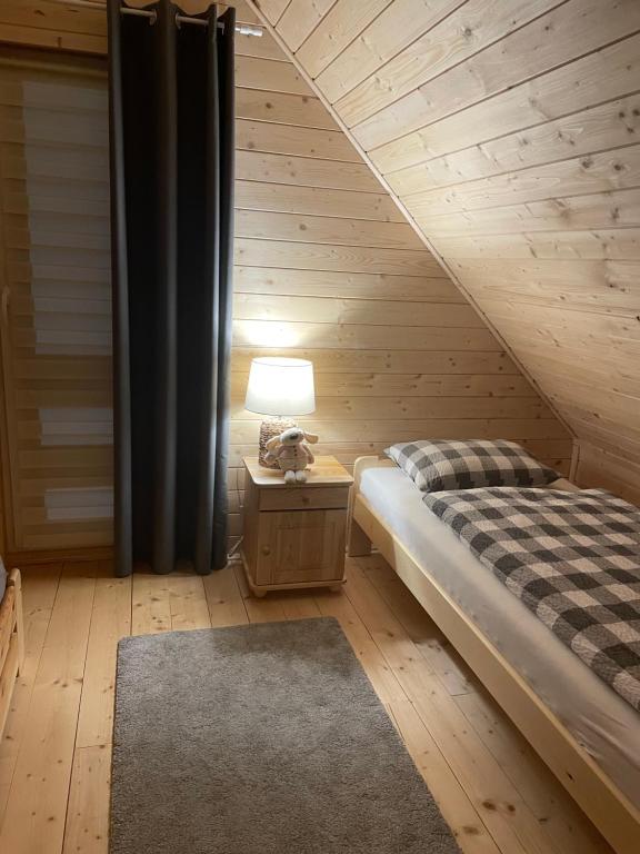a bedroom with a bed and a table with a lamp at Leśna Osada -Dominikowo -sauna , balia in Dominikowo