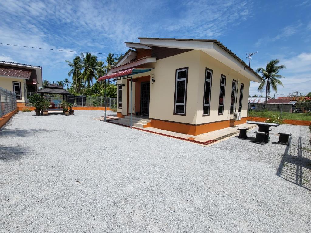 un pequeño edificio con bancos delante en SMART 2.0 Homestay Pantai Kemayang Bachok, en Bachok