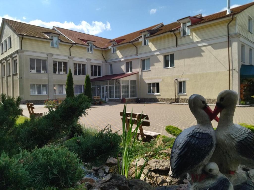 two birds standing in front of a building at Zhyttedar in Ulanov