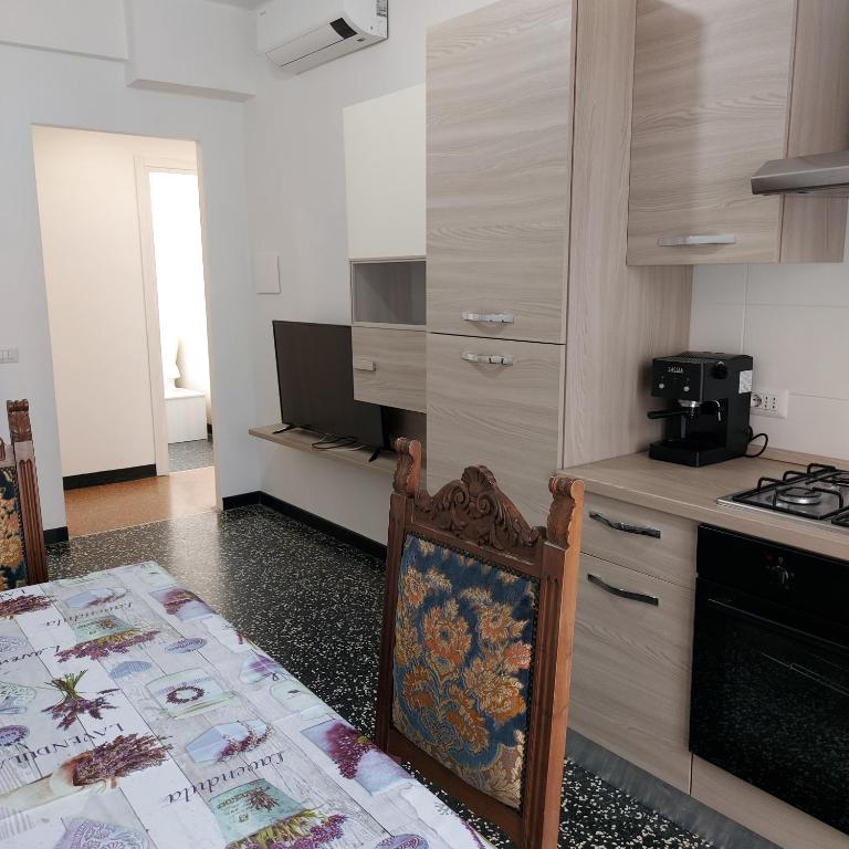 uma cozinha com uma mesa e uma cozinha com um fogão em SEA COTTAGE em Savona