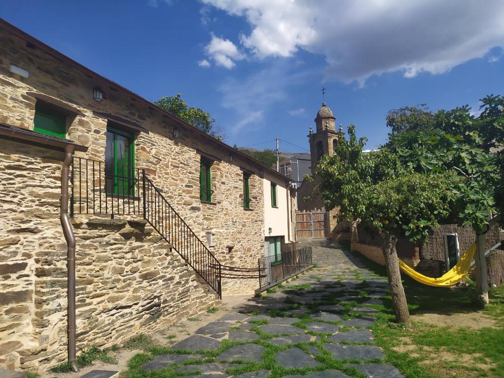 an alley in an old building with a yellow hammock at Eco dos Teixos in Casayo