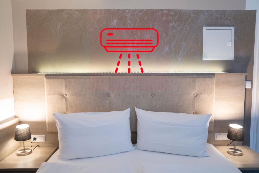 シュトゥットガルトにあるAlpha & Omega Hotelのベッド(上に赤い椅子付)