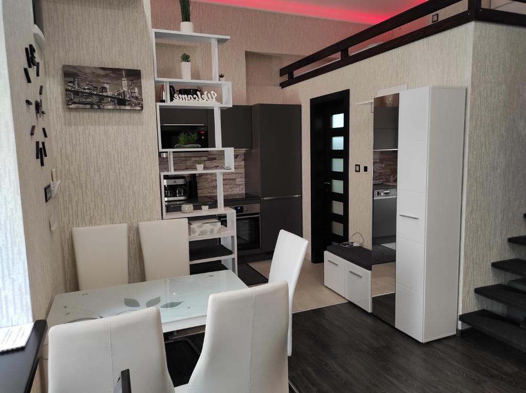 a dining room with a white table and white chairs at Corvinus Apartman in Budapest