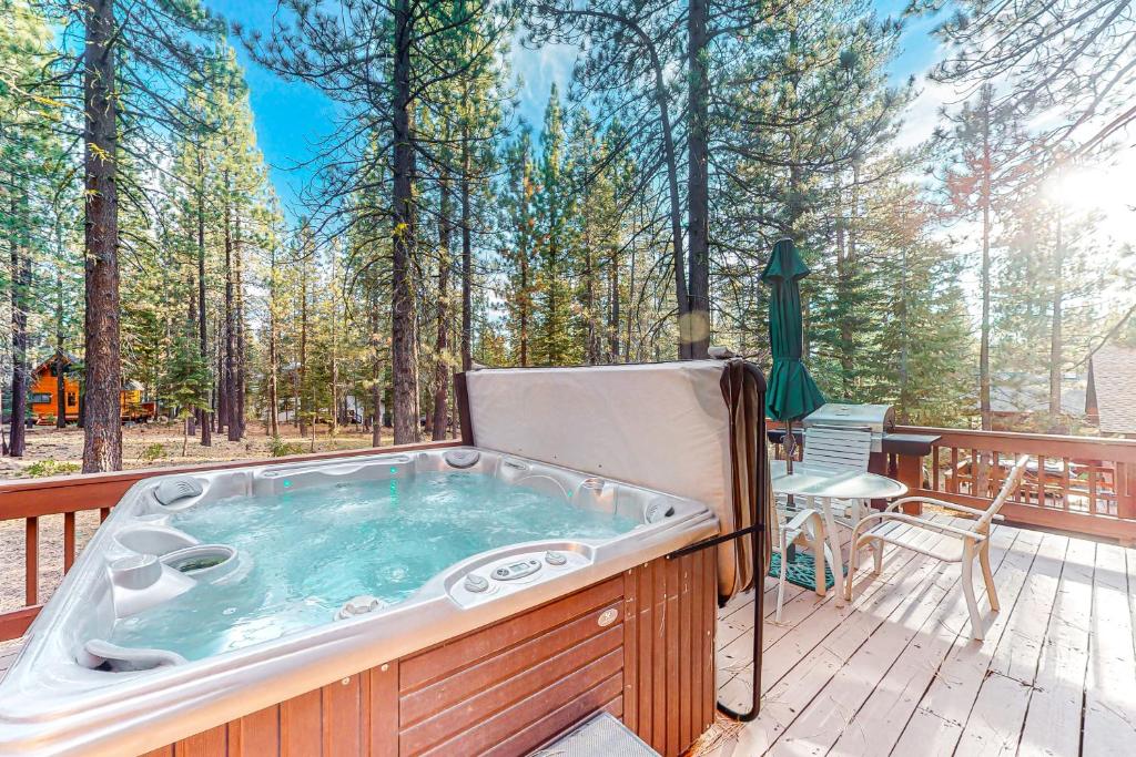 a jacuzzi tub on a deck in the woods at The Bear's Lair House in Truckee