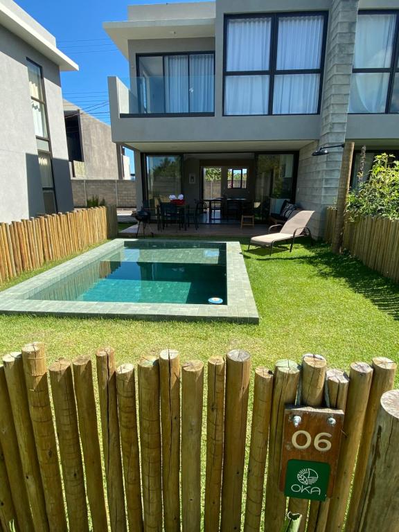 une maison avec une piscine en face d'une clôture dans l'établissement Oka Milagres Residence 06, à São Miguel dos Milagres