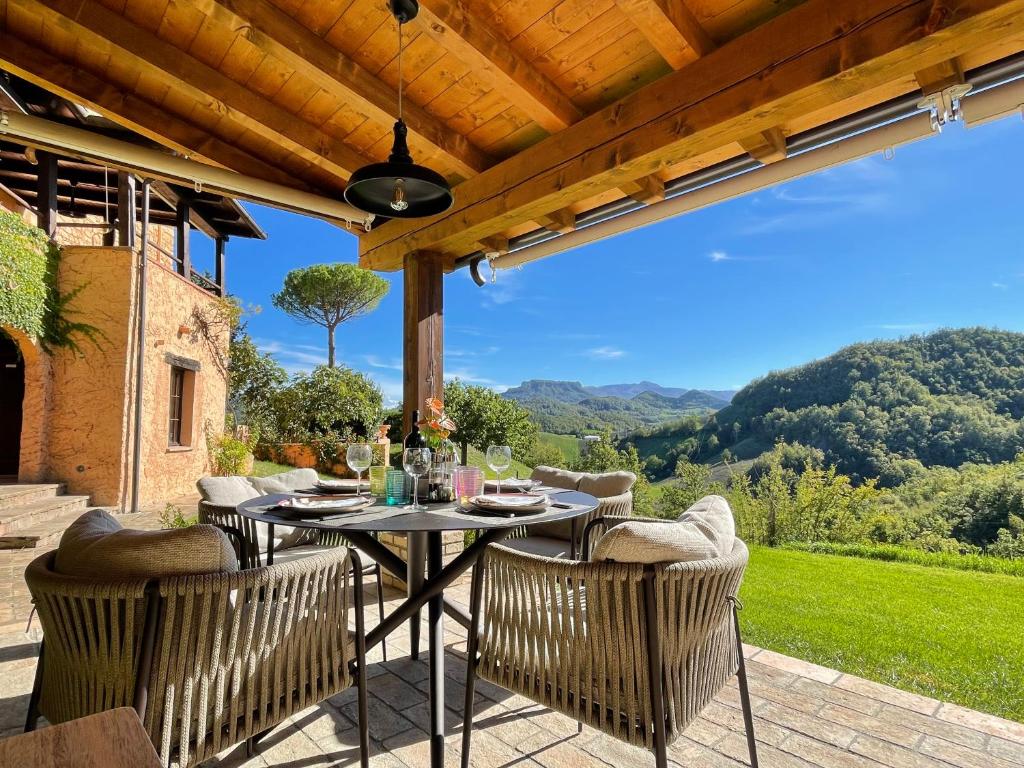 a table with chairs on a patio with a view at Val di Codena - Holiday Home in Vetto