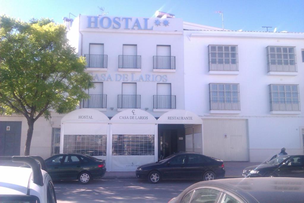 un bâtiment blanc avec des voitures garées devant lui dans l'établissement Casa de Larios, à Estepa