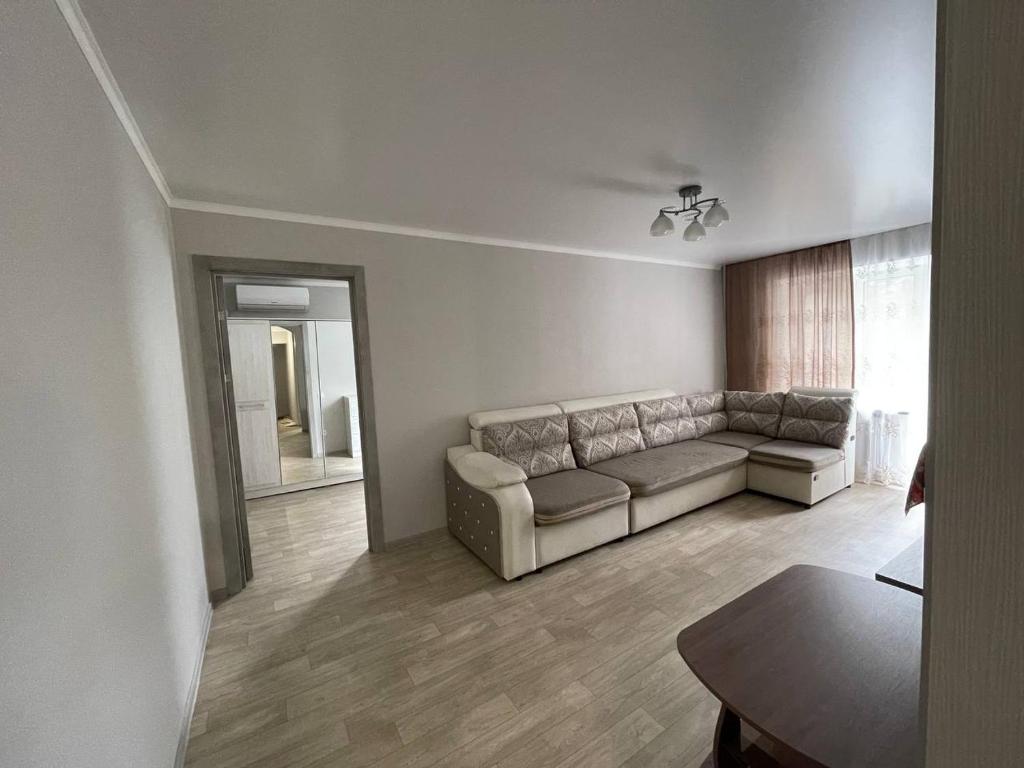Una sala de estar con un sofá y un espejo. en Apartment on Kievskaya street, en Bishkek