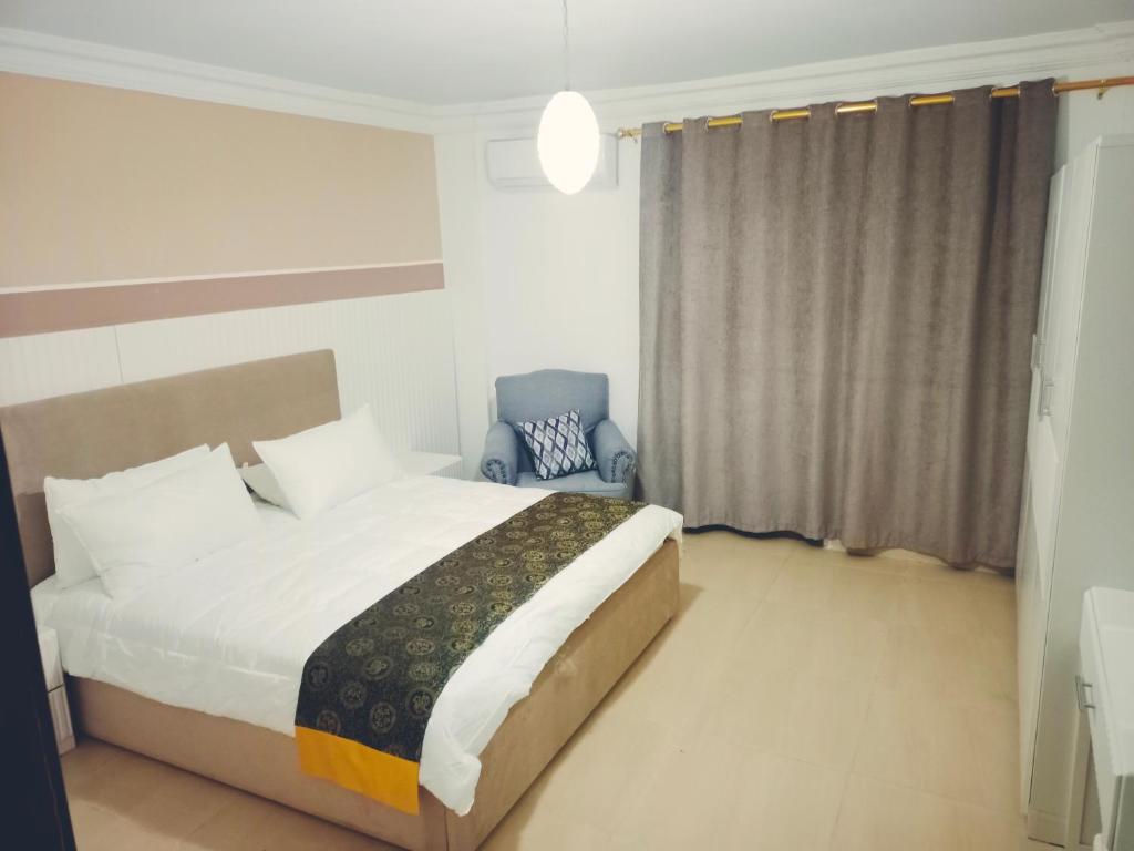a bedroom with a bed and a blue chair at Pomegranate Tree in Wadi Musa