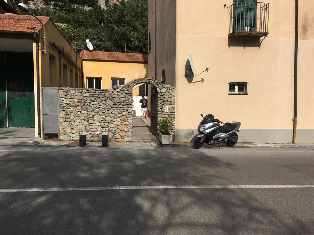 ein Motorrad, das auf einer Straße neben einem Gebäude geparkt ist in der Unterkunft casa 102 in Finale Ligure