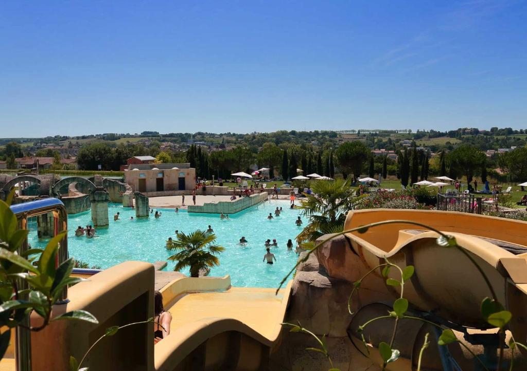 - une piscine dans un parc à thème avec des personnes dans l'établissement Casita Néracaise, à Nérac