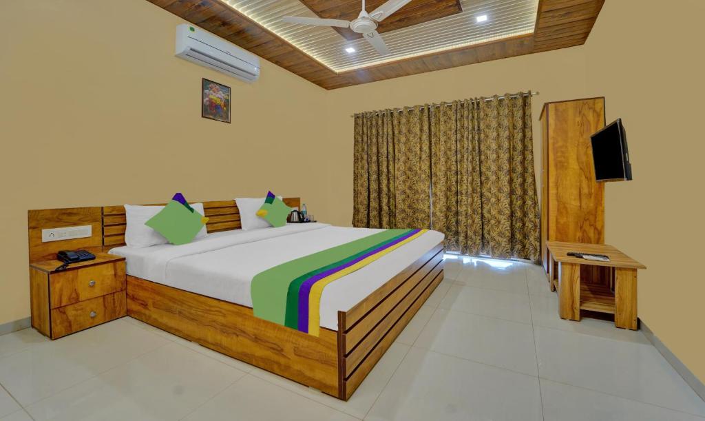 1 dormitorio con 1 cama y TV en Treebo Trend Iceberg, en Mahabaleshwar