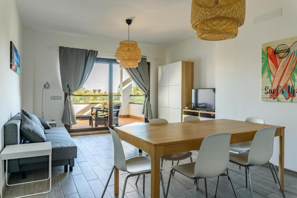 jadalnia z drewnianym stołem i krzesłami w obiekcie Modern apartment in residential complex with pools w mieście Costa de Antigua