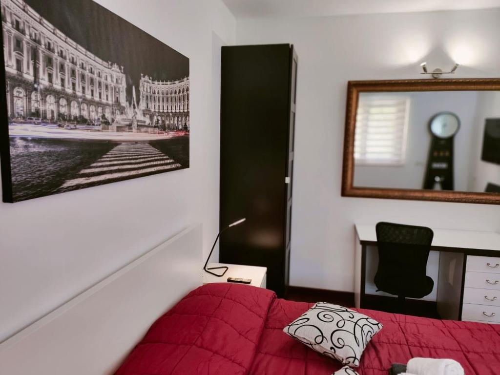 sypialnia z czerwonym łóżkiem i zdjęciem na ścianie w obiekcie Ada’s Garden House w Rzymie