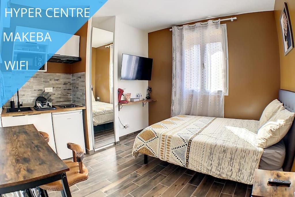 Un dormitorio con una cama y una mesa y una cocina. en STUDIO GARE AMIENS TOUT ÉQUIPÉ NETFLIX WIFI 2PERS, en Amiens