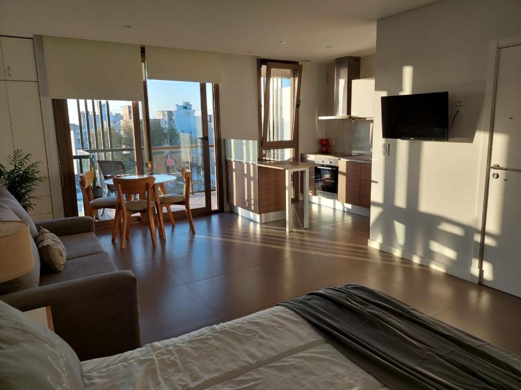 a kitchen and living room with a couch and a table at CALIDO Y MODERNO monoambiente con cochera in Mar del Plata
