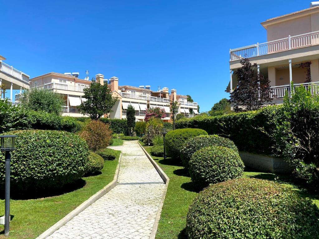 a garden with bushes and a path in front of a building at Ada’s Garden House in Rome