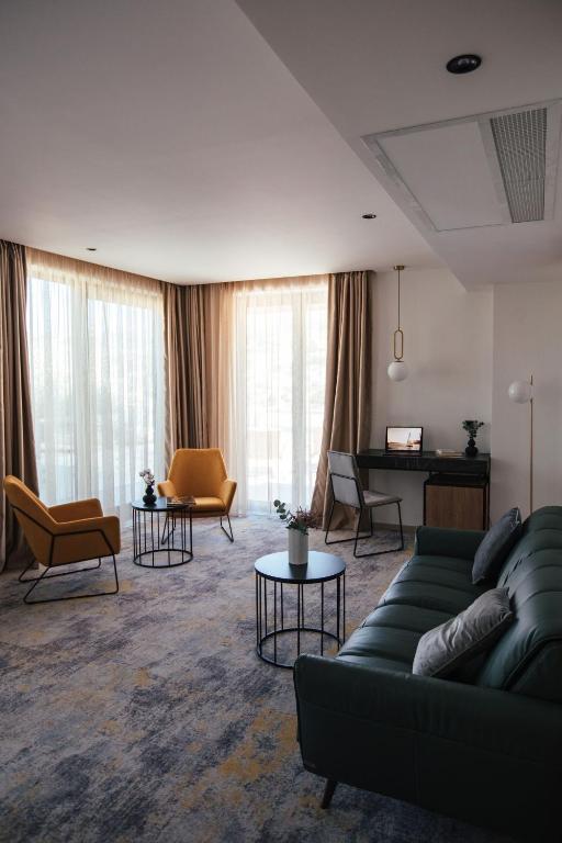 a living room with a couch and chairs and a piano at City Hotel Dubrovnik in Dubrovnik