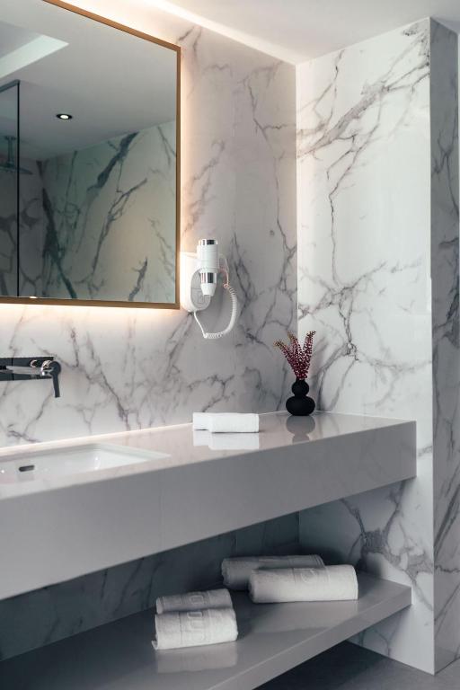 a bathroom with a sink and a mirror and towels at City Hotel Dubrovnik in Dubrovnik