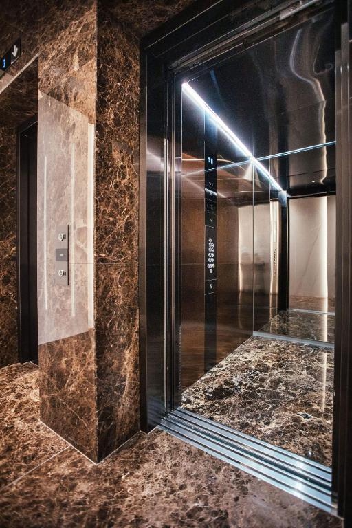an elevator in a hotel lobby with a marble floor at City Hotel Dubrovnik in Dubrovnik