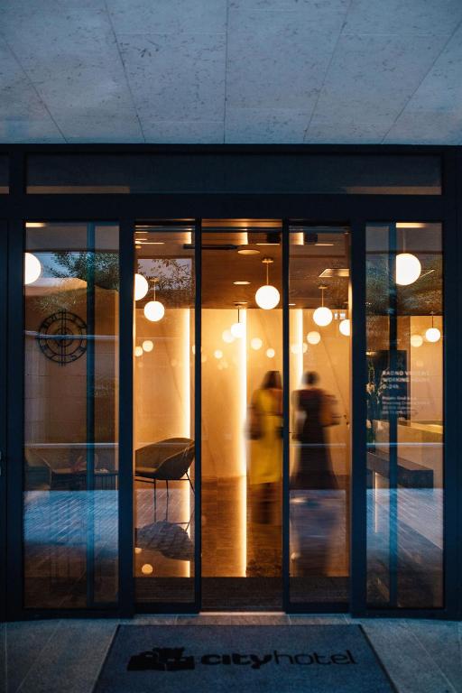 a building with glass doors with a person walking outside at City Hotel Dubrovnik in Dubrovnik