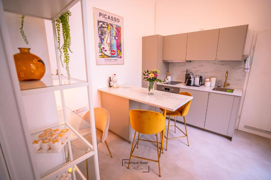 een kleine keuken met een tafel en gele stoelen bij Boutique Hotel Kerlin in Berlijn