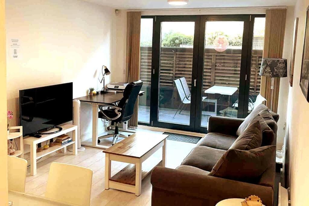 a living room with a couch and a table and a desk at Two-Bedroom Luxury Apartment with Workspace, Free Parking & coffee in Birmingham