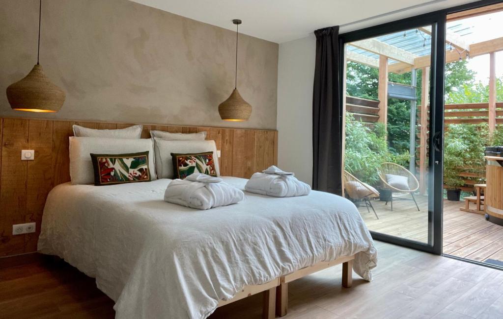 a bedroom with a bed with two pillows on it at Madame Imagine, Lodges & SPA Epinal in Épinal