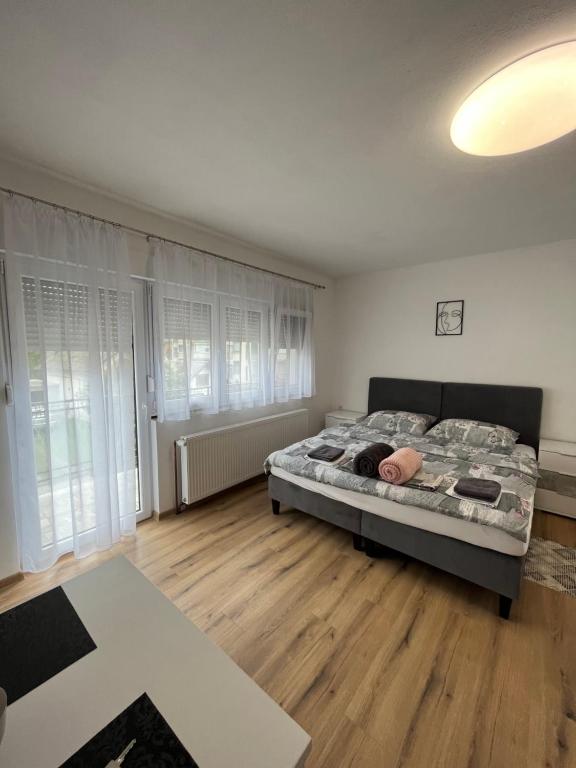 um quarto com uma cama e piso em madeira em OPG - ZM APARTMANI MARTINOVIĆ em Novska